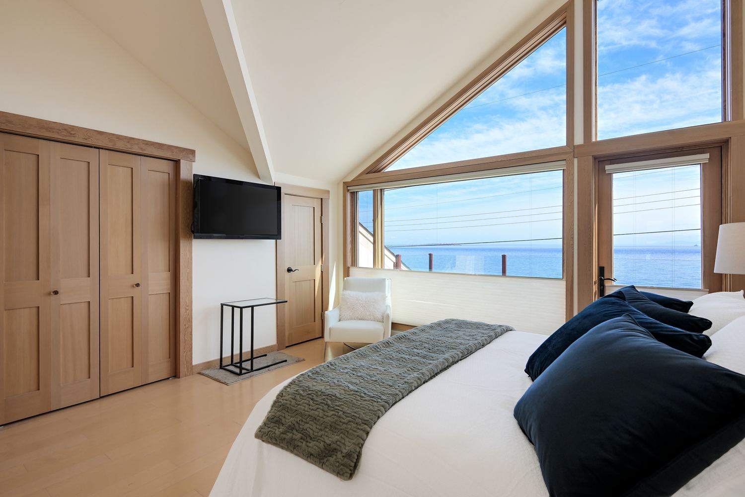 Primary bedroom with vaulted ceiling and ocean view