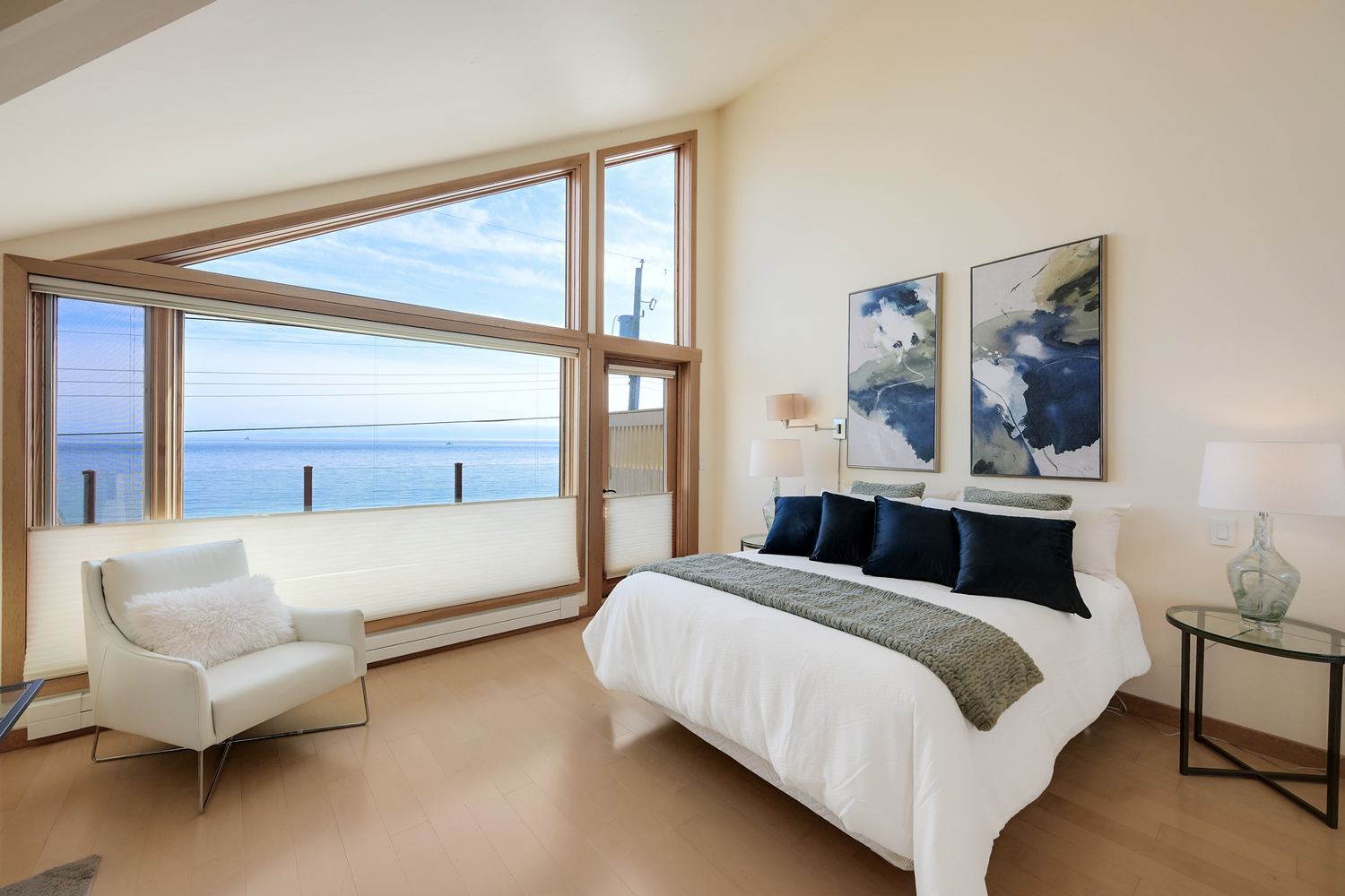 Primary bedroom with window wall and ocean view